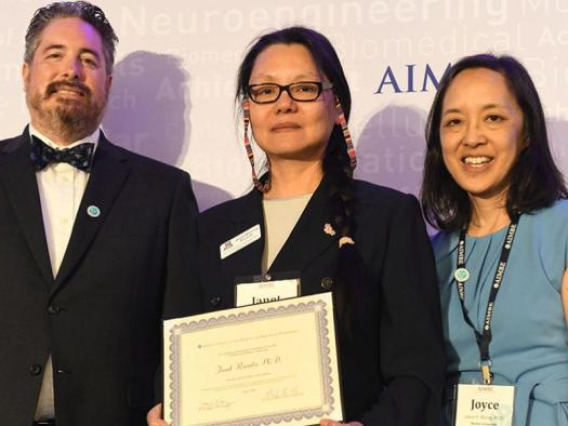 Janet Roveda, center, accepts her AIMBE fellowship certificate at the 2024 induction ceremony on March 25.