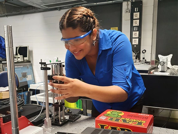 student, wearing safety google, working in lab