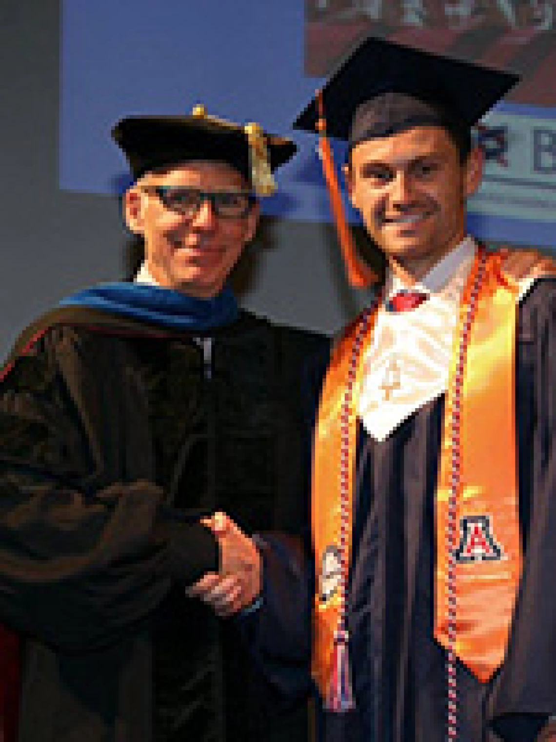 professor and student in graduation regallia