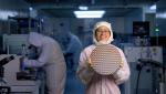 Materials science and engineering graduate student Christina Dinh holds a chemical mechanical polish test wafer in the existing micro/nano fabrication center.