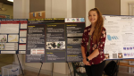 Kayme Konecny standing in front of her poster about a portable magnetic-levitation microscope