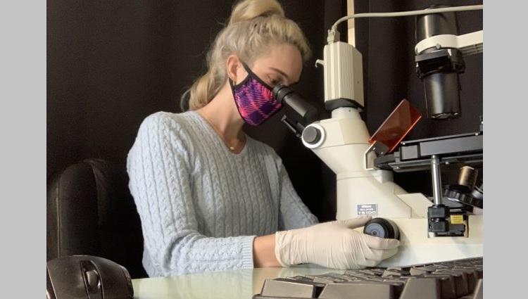 Lane Breshears looks into a microscope