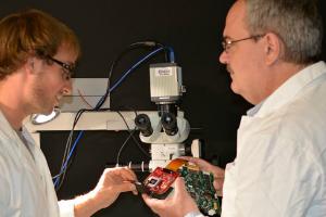 Professor Marek Romanowski (right) assembles an augmented microscope with aid from doctoral student Jeffrey Watson. (2015)