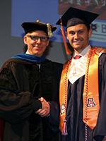 Department Head Art Gmitro shakes Tyler Toth's hand as he crosses the stage at BME's convocation ceremony