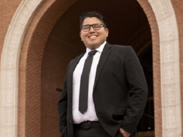 person in suit, wearing glasses, smiling