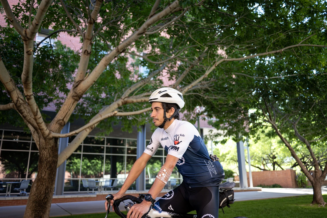 A participant using wearable health device rides a bicycle at the University of Arizona.
