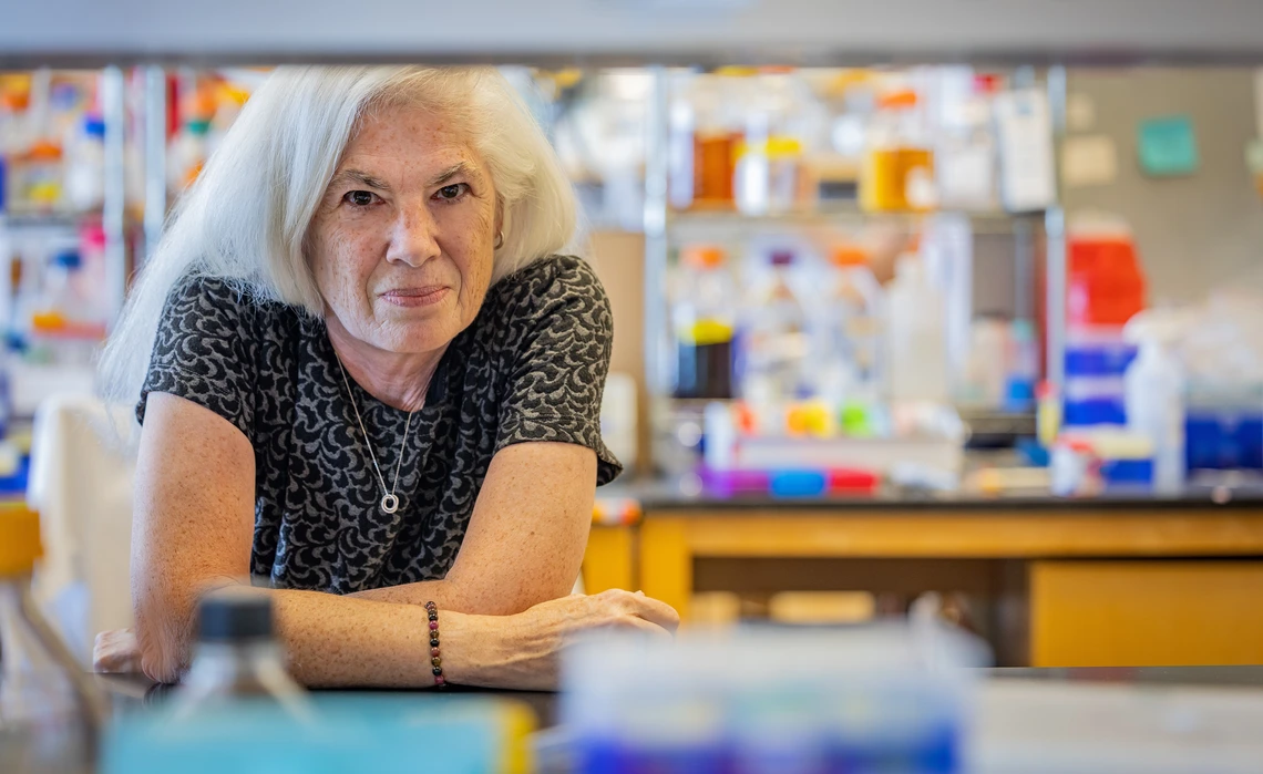 A women poses behind lab equipment