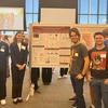 Students stand around a poster.