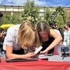 Two young women fix a solar tracker.