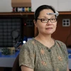 A woman with dark hair wears tech on her forehead.
