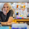 A women poses behind lab equipment